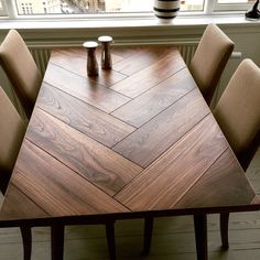 a wooden table sitting in front of a window