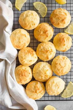 lemon muffins on a cooling rack with lemon wedges and a white towel