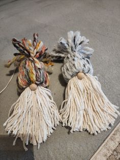 two yarn tassels are laying on the ground