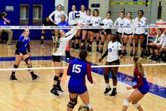 a group of women playing volleyball on a court