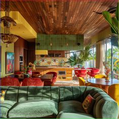 a living room filled with furniture next to a kitchen and dining room table in front of a large window