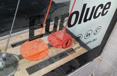 an orange and black object sitting on top of a wooden table in front of a store window