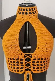 an orange crocheted halter top on a mannequin