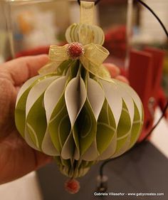 a hand holding a green and white ornament