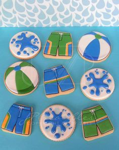 decorated cookies in the shape of swimsuits and shorts on a blue tablecloth