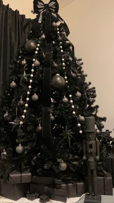 a decorated christmas tree with black and silver ornaments