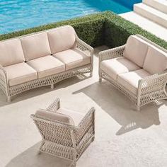 wicker patio furniture sitting next to a swimming pool