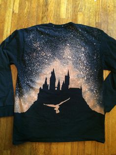 a harry potter shirt with hogwart's castle on the back and stars in the sky