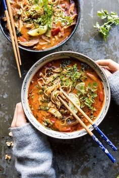 two bowls of soup with chopsticks on the side