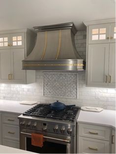 a stove top oven sitting inside of a kitchen next to white counter tops and cabinets