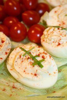 deviled eggs with tomatoes and herbs on a plate