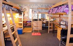 a room with bunk beds and desks in it