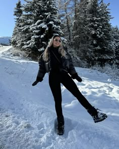 a woman standing in the snow with her legs spread out