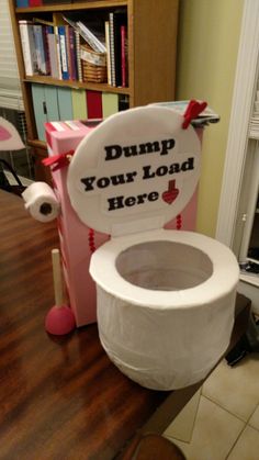 a toilet sitting on top of a wooden floor next to a book shelf