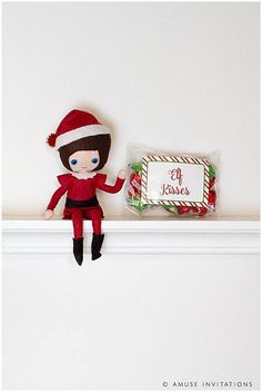 an elf doll sitting on top of a shelf next to a candy bar