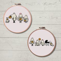 two cross - stitch hoop paintings depicting dogs, cats and pumpkins on white wood