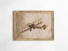 an old airplane is flying in the air on a wall with a wooden frame above it