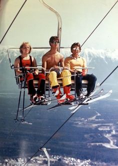 two men and a woman sitting on a ski lift