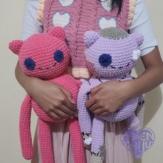 a woman holding two crocheted teddy bears