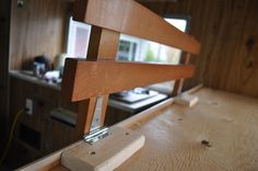 a close up of a wooden bench in a room with wood paneling on the walls