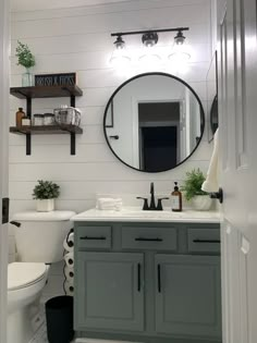 a bathroom with a toilet, sink and mirror in it's centerpieces