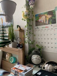 a desk with various items on it in front of a wall calendar and other decorations