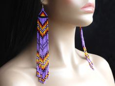 a mannequin head wearing purple and yellow beaded earrings