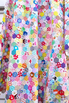 the back of a woman's dress made out of colorful buttons and polka dots