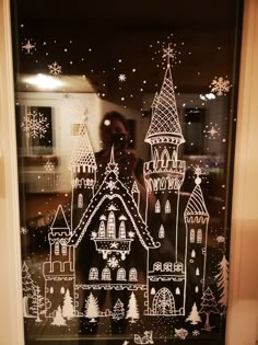 a window with a castle drawn on it and snow flakes all over the windows