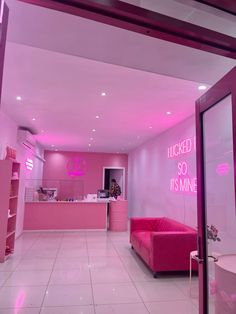 the inside of a pink and white store with neon signs on the wall above it