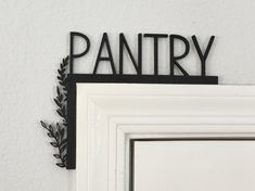 a sign that says pantry hanging on the wall next to a white door with black trim