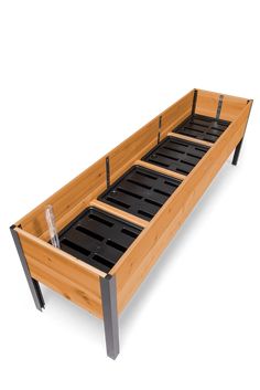 a wooden bed frame with metal legs and black trays on each side, in front of a white background