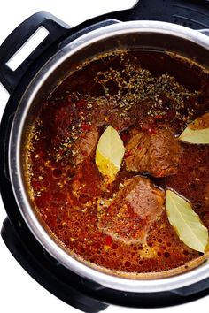 a pot filled with meat and spices on top of a table