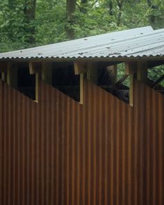 the roof of a building with metal sheets on it and trees in the back ground