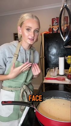 a woman standing in front of a frying pan