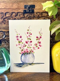 a watercolor painting of pink flowers in a blue vase on a table next to two yellow vases