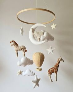 a crib mobile with giraffes, hot air balloon and stars