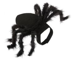 a spider mask with black feathers on it's head and tail, sitting on top of a white surface