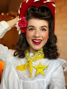 a woman wearing a red and white hat with stars on it's collar, smiling at the camera