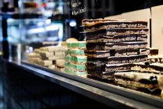 there are many different desserts on display in the store front window, including chocolate and marshmallow