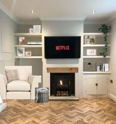 a living room with a fireplace and television mounted on the wall