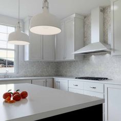 a kitchen with white cabinets and an island in the middle, two hanging lights above it