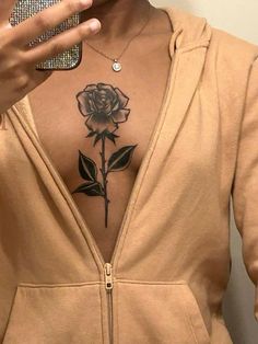 a woman with a rose tattoo on her chest holding a cell phone to her ear