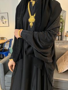 Elevate your style with our Butterfly Abaya Collection  Introducing our new Khaleeji Butterfly Abaya, a perfect blend of style in Black. This elegant piece features a thoughtful design, made with Satin fabric and black gemstones,  Made in UAE Dry Clean Only Model's Details Our model, a UK size 8 with a height of 5.6, gracefully wears a size 56, showcasing the flattering fit and versatility of this Butterfly Abaya. Key Features: * Stylish Butterfly Design * popup buttoned sleeves  * Batwing Sleev Elegant Long Niqab For Eid, Elegant Dabka Khimar For Eid, Elegant Dabka Khimar, Elegant Black Festive Thobe, Gold Long Sleeve Abaya With Dabka, Traditional Long Gold Abaya, Black Abaya For Eid Festive Occasion, Gold Long Abaya For Eid, Gold Long Abaya For Festive Occasions