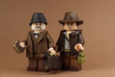 two lego figurines standing next to each other on a brown surface with one holding a suitcase and the other carrying a briefcase