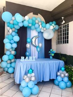 a blue and silver balloon arch for a baby shower