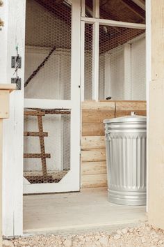 a metal trash can sitting next to a white door