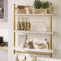 the shelves are filled with dishes, glasses and other kitchen items in white and gold