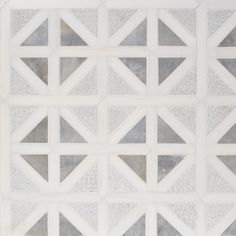 a white and grey tiled wall with geometric designs