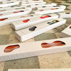 several white boxes with red and black designs on them sitting on a tiled floor next to each other